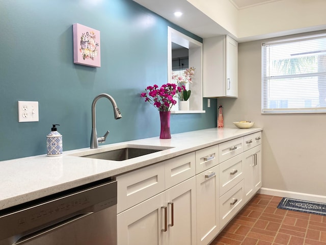 kitchen featuring white cabinets, light stone countertops, and dishwasher