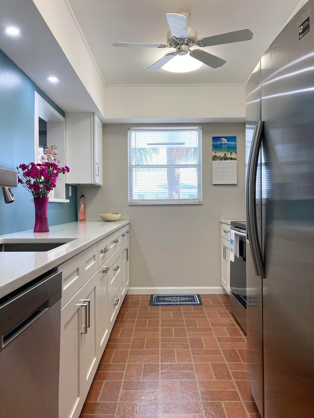 kitchen with sink, ceiling fan, white cabinetry, and stainless steel appliances