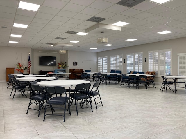 tiled dining area featuring a paneled ceiling