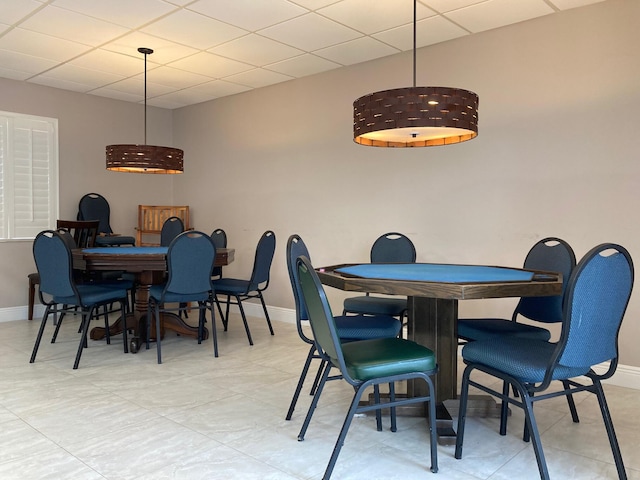 dining room featuring a paneled ceiling and light tile floors