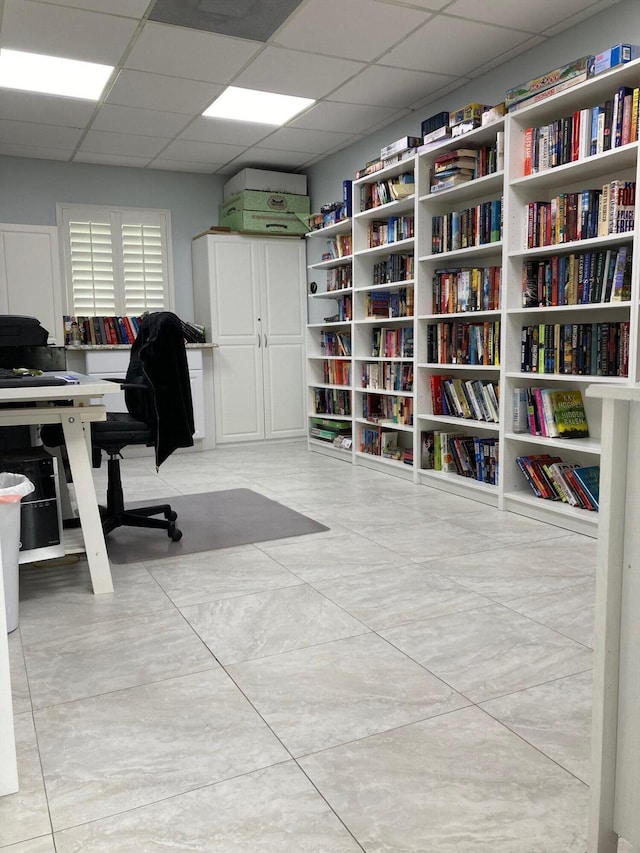 tiled office space with a paneled ceiling