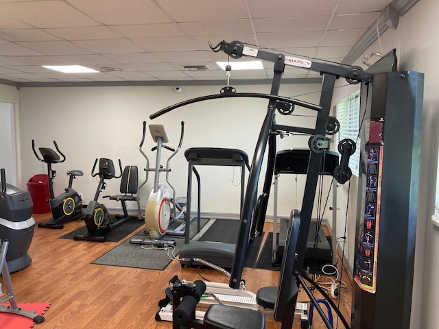 workout area featuring hardwood / wood-style floors and a drop ceiling