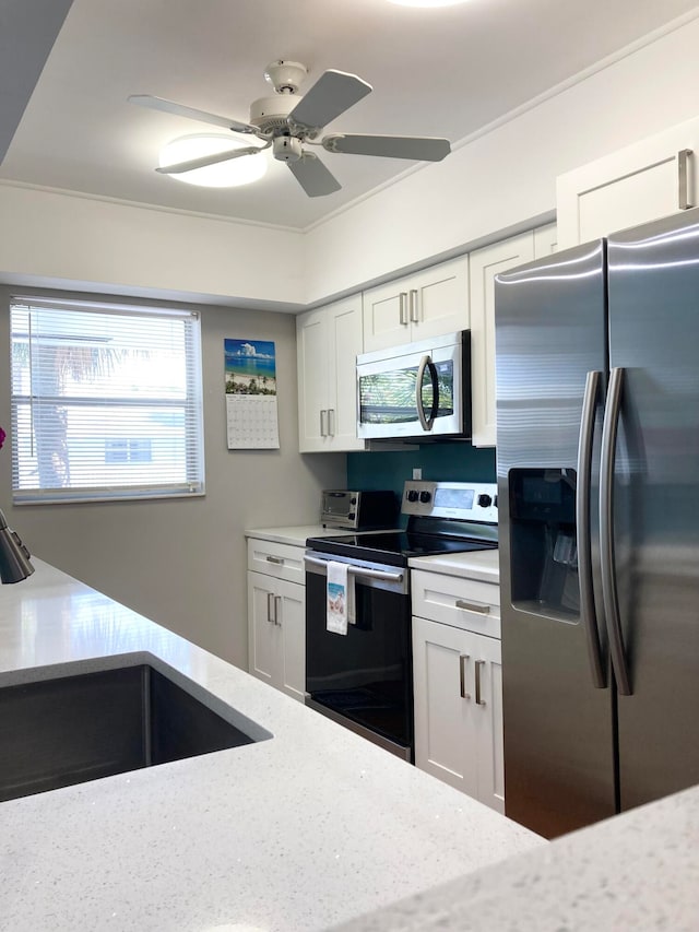 kitchen featuring appliances with stainless steel finishes, ceiling fan, and white cabinetry