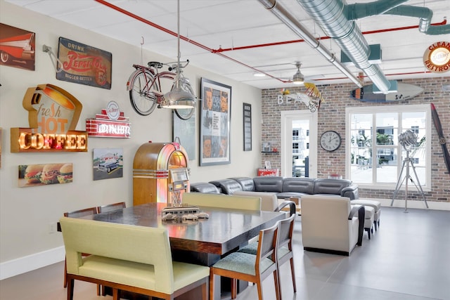 dining room featuring brick wall