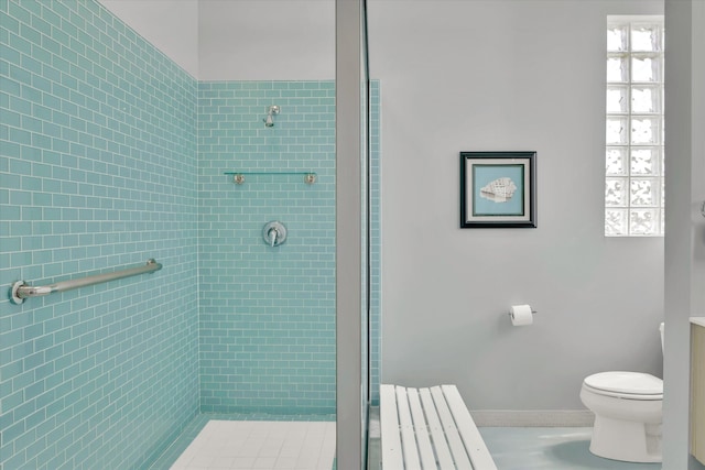 bathroom with toilet and a tile shower