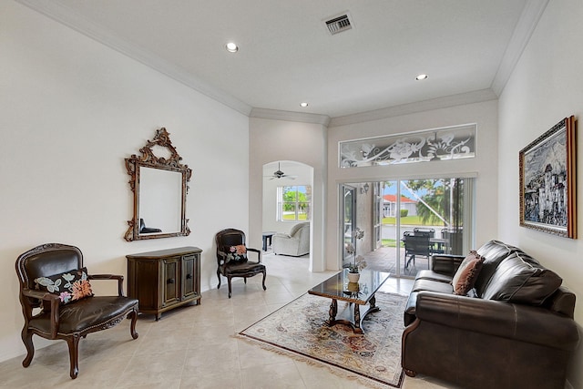 tiled living room featuring ceiling fan, crown molding, and a high ceiling