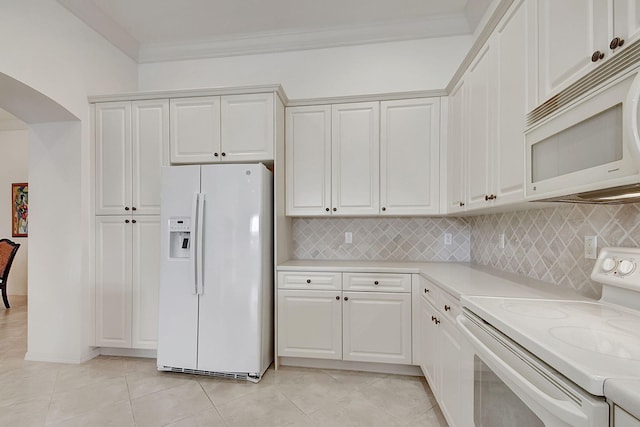 kitchen with ornamental molding, white cabinets, light tile floors, and white appliances