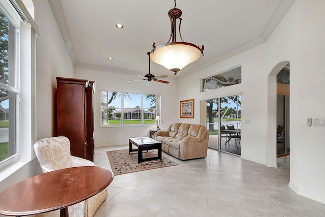 interior space with ceiling fan, crown molding, and light tile floors