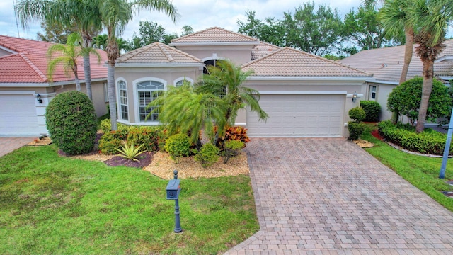 mediterranean / spanish-style home with a front lawn and a garage