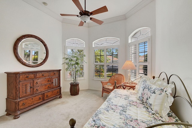 bedroom featuring ceiling fan, ornamental molding, light carpet, and a high ceiling