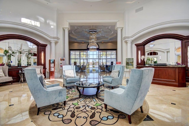 sitting room with ornamental molding, ornate columns, light tile floors, and a high ceiling