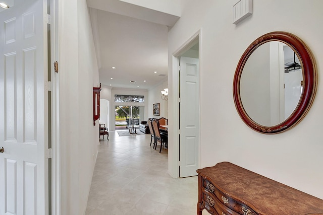 hall featuring an inviting chandelier, ornamental molding, and light tile floors