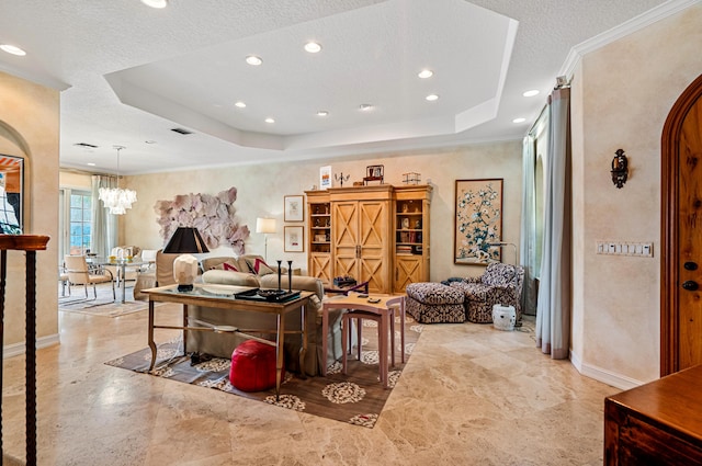 tiled living room with ornamental molding, a textured ceiling, a notable chandelier, and a tray ceiling