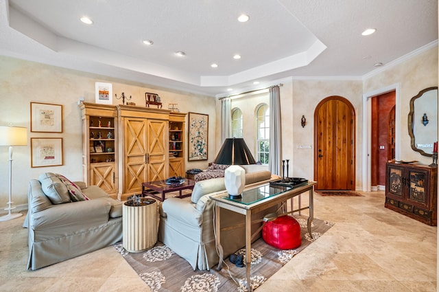 tiled living room with crown molding and a tray ceiling