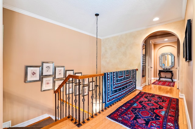 hallway with ornamental molding and light wood-type flooring