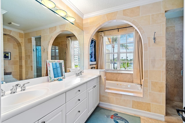 bathroom featuring large vanity, a textured ceiling, dual sinks, tiled bath, and ornamental molding