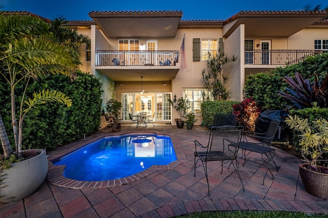 pool at twilight with a patio area and french doors