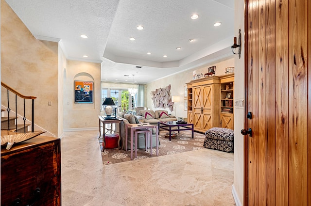 interior space with a textured ceiling, a raised ceiling, and light tile flooring