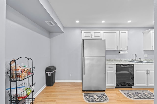 kitchen with white cabinetry, dishwasher, stainless steel fridge, and light wood-type flooring