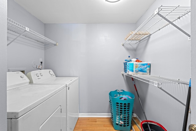 laundry area with light hardwood / wood-style floors and independent washer and dryer