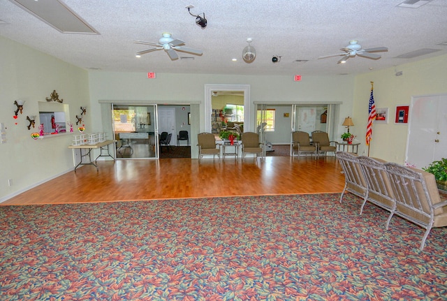 miscellaneous room with ceiling fan, wood-type flooring, and a textured ceiling