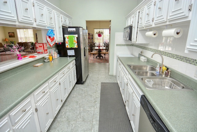 kitchen with sink, decorative backsplash, stainless steel appliances, and white cabinets