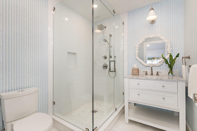 bathroom featuring tile flooring, walk in shower, vanity, and toilet