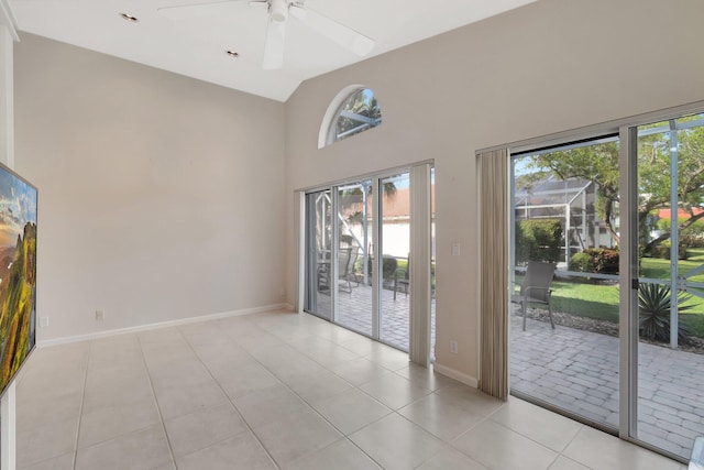 interior space with vaulted ceiling, ceiling fan, and light tile patterned flooring