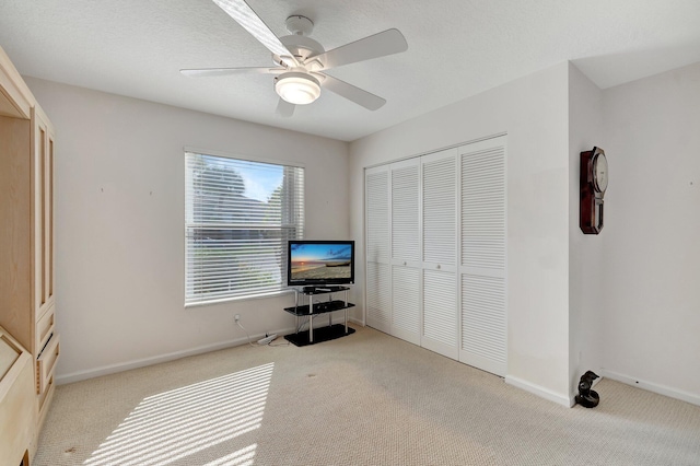 unfurnished bedroom featuring ceiling fan, a closet, and light carpet