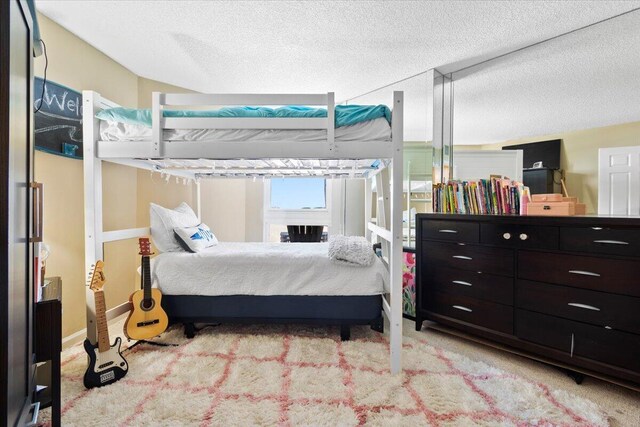 carpeted bedroom featuring ceiling fan and a textured ceiling