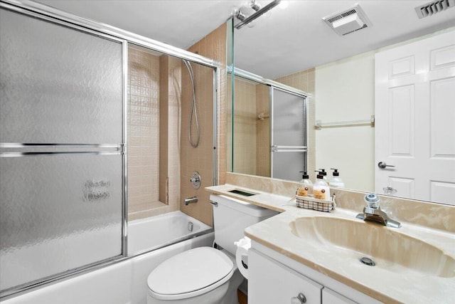 full bathroom with combined bath / shower with glass door, vanity, and toilet