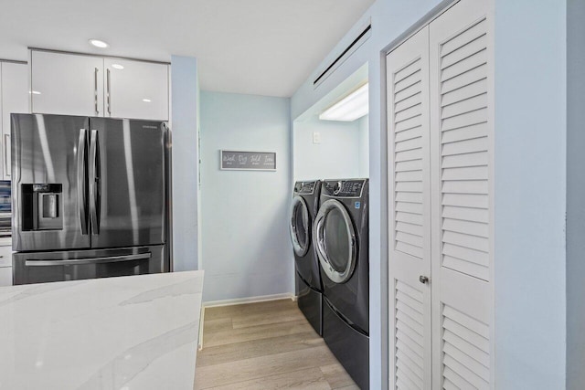 washroom with light hardwood / wood-style flooring and separate washer and dryer