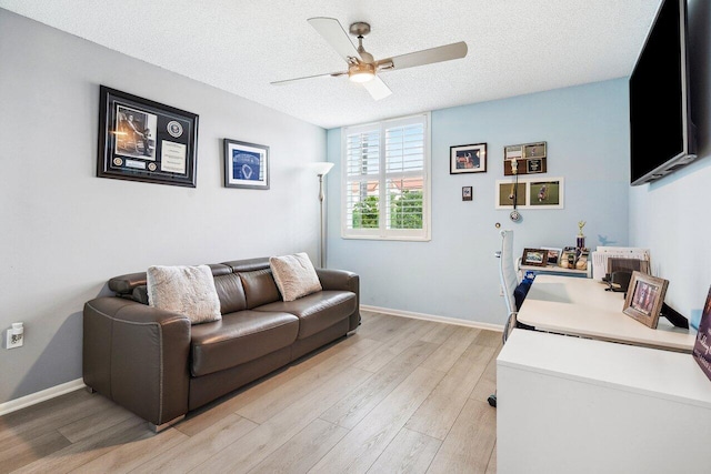 living room with a textured ceiling, ceiling fan, and light hardwood / wood-style floors