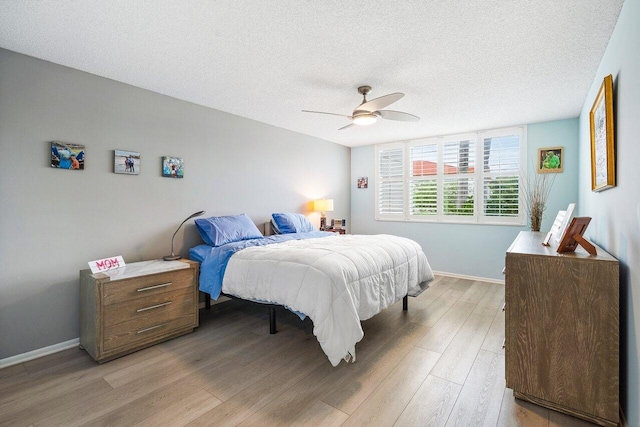 bedroom featuring wood-type flooring, ceiling fan, and a textured ceiling