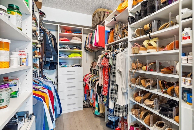 walk in closet with light hardwood / wood-style flooring