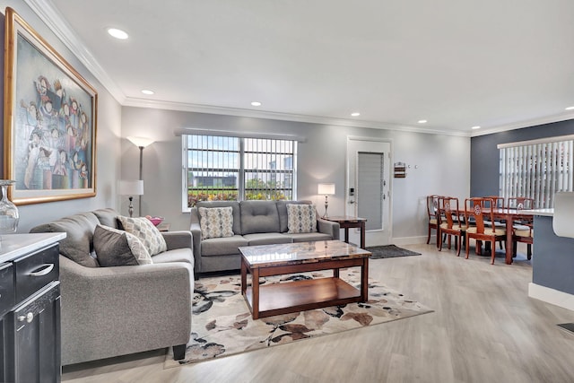 living area with baseboards, crown molding, light wood-type flooring, and recessed lighting