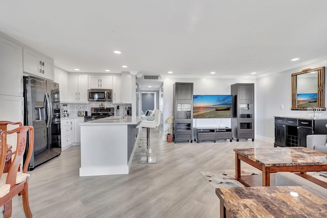 kitchen featuring tasteful backsplash, visible vents, a breakfast bar, stainless steel appliances, and a sink