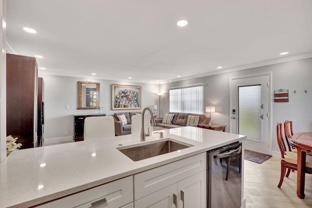 kitchen with a sink, white cabinetry, open floor plan, light stone countertops, and dishwasher