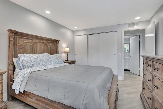 bedroom featuring light wood-type flooring, visible vents, a closet, and recessed lighting