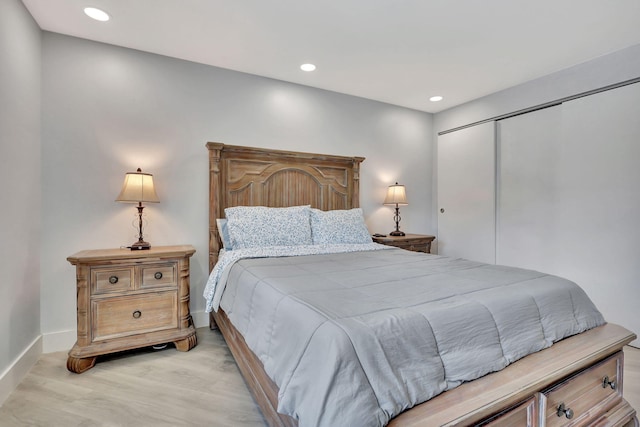 bedroom featuring light wood-type flooring, baseboards, a closet, and recessed lighting