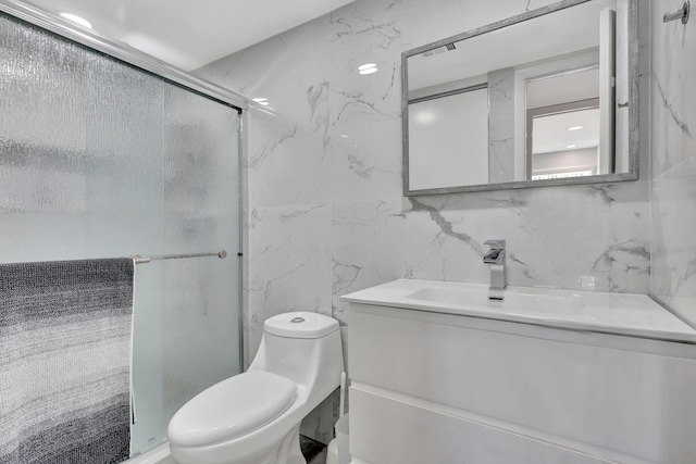 bathroom featuring tile walls, vanity, toilet, and a shower stall