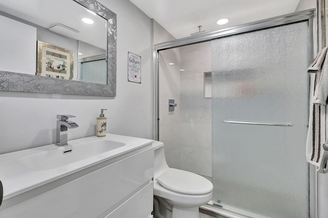 bathroom with vanity, a shower stall, toilet, and recessed lighting