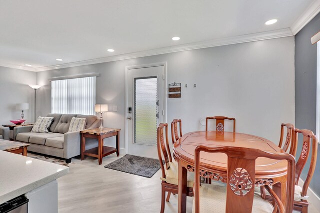 dining area featuring light hardwood / wood-style floors and crown molding