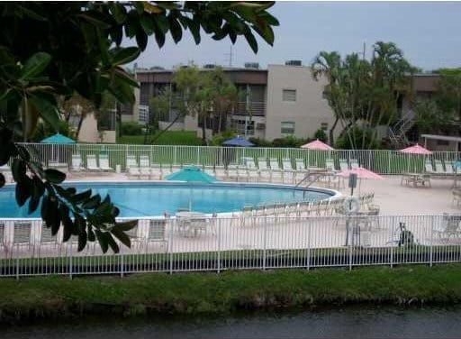 pool with a patio area and fence