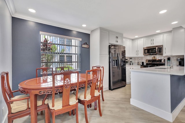 dining area with light wood-style flooring, crown molding, and recessed lighting