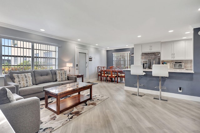 living area with a toaster, crown molding, light wood finished floors, recessed lighting, and baseboards