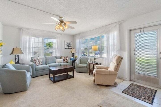 tiled living room with ceiling fan and a textured ceiling