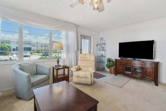 carpeted living room with ceiling fan and a textured ceiling