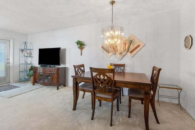 dining area featuring light colored carpet, an inviting chandelier, and a textured ceiling