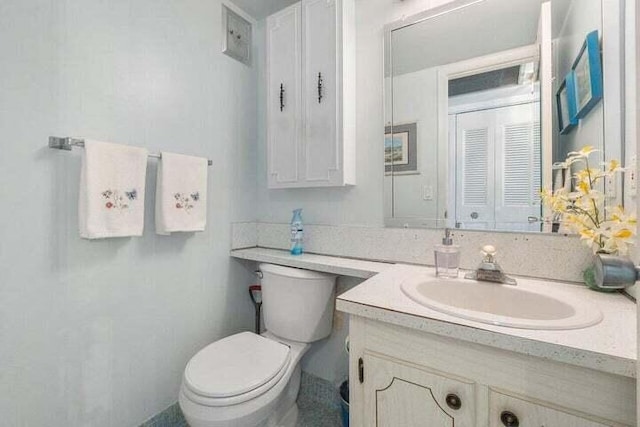 bathroom with vanity with extensive cabinet space and toilet